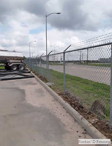 Commercial grade chain-link fence with barbed wire