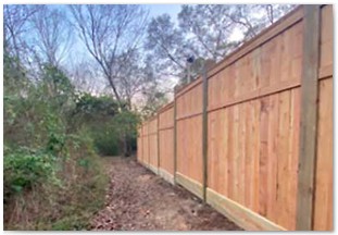 Eight foot capped and trimmed western red cedar fence with 6x6 posts stair stepped down on one side