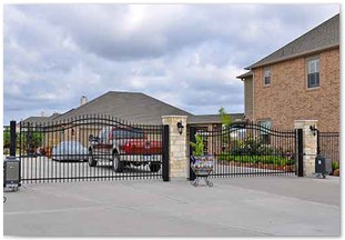 Double wrought iron gateways with decorative brick columns in Whispering Lakes